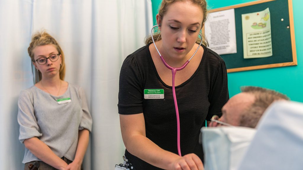 Medical students examining a patient